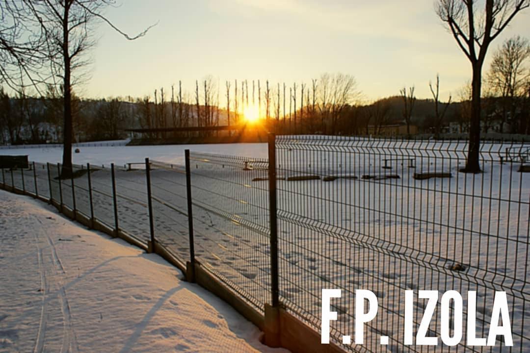 Panelowe ogrodzenie z siatki zgrzewanej na tle zimowego krajobrazu o zachodzie słońca, widoczny tekst 'F.P. IZOLA'.