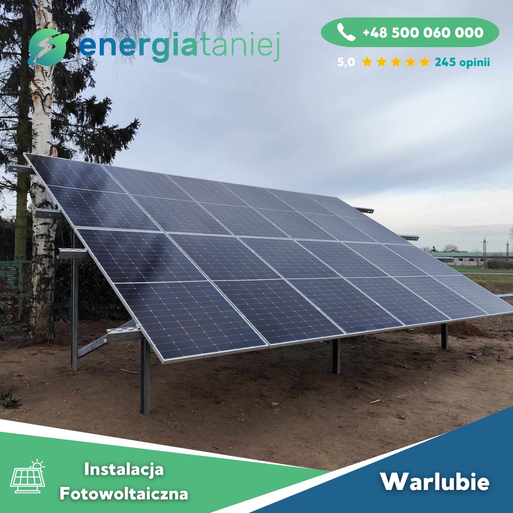 Instalacja paneli słonecznych na konstrukcji wsporczej, widok z niskiej perspektywy, w tle drzewo i zabudowania, logo firmy w górnym rogu.