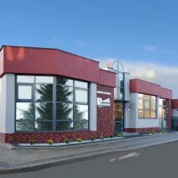 Budynek drukarni Polraster z dużymi oknami, ceglaną fasadą i logo firmy. Widok na ulicę i drzewa w tle, błękitne niebo.