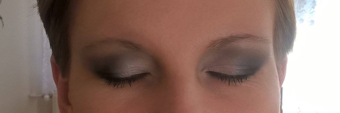 Zbliżenie na oczy z ciemnym, przydymionym cieniem do powiek i wytuszowanymi rzęsami.