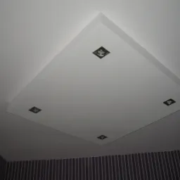 Podwieszany sufit z oświetleniem punktowym w łazience w Jeleniej Górze. Cztery małe lampki w kwadratowych oprawach. Ściana z pionowymi paskami w tle.