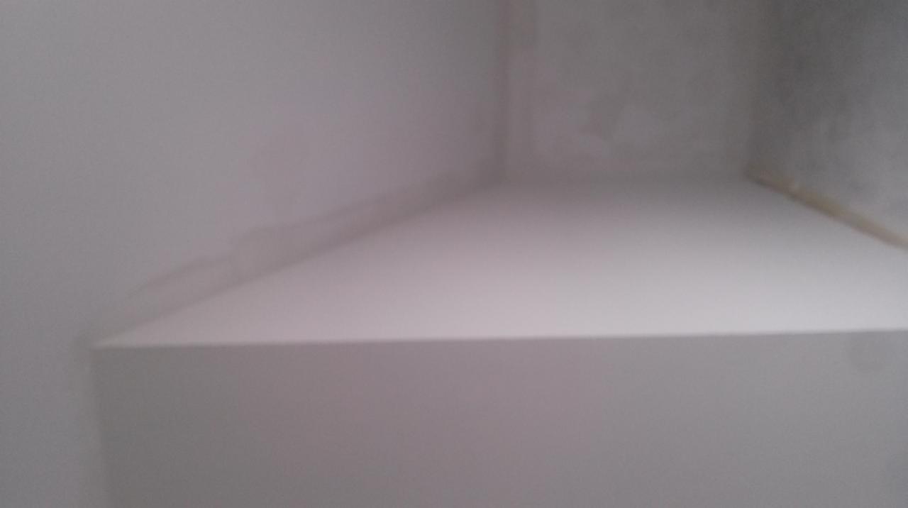 Świeżo pomalowany, jasny narożnik pokoju z widocznymi śladami taśmy malarskiej przy suficie, sugerujący etap wykończeniowy prac malarskich.