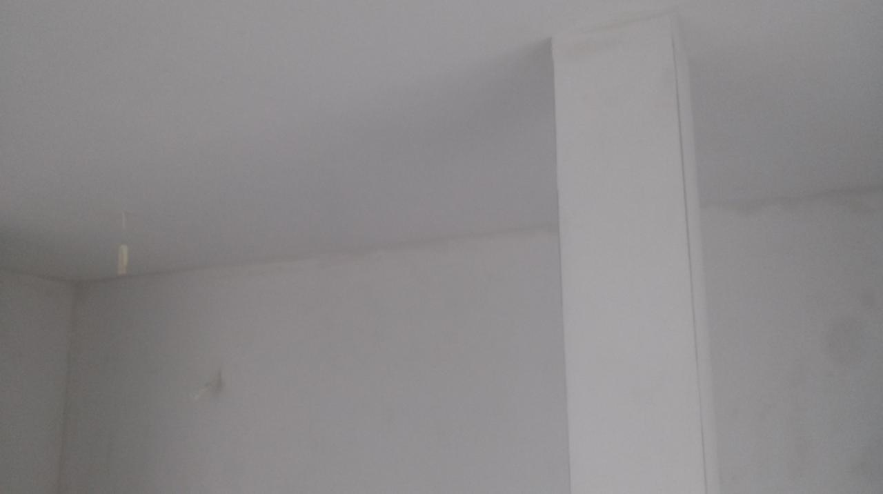 Gładkie, białe ściany i filar w rogu pomieszczenia po malowaniu w Somonino, widoczne niedoskonałości. Minimalistyczne wnętrze gotowe do dalszych prac wykończeniowych.