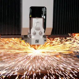 Precyzyjne cięcie metalu laserem CNC z intensywnym snopem iskier, widoczna głowica lasera z logo producenta.