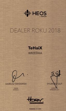 Pamiątkowa tablica 'Dealer Roku 2018' marki HEOS by Denon dla firmy TeHaiX z Wrześni, z podpisami Dariusza Świderskiego i Sylwiusza Gut na tle szczotkowanego metalu.