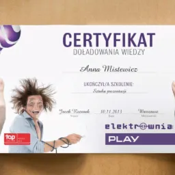 Certyfikat ukończenia szkolenia z zakresu sztuki prezentacji, z humorystycznym wizerunkiem osoby po porażeniu prądem, trzymany w dłoniach na beżowym tle.