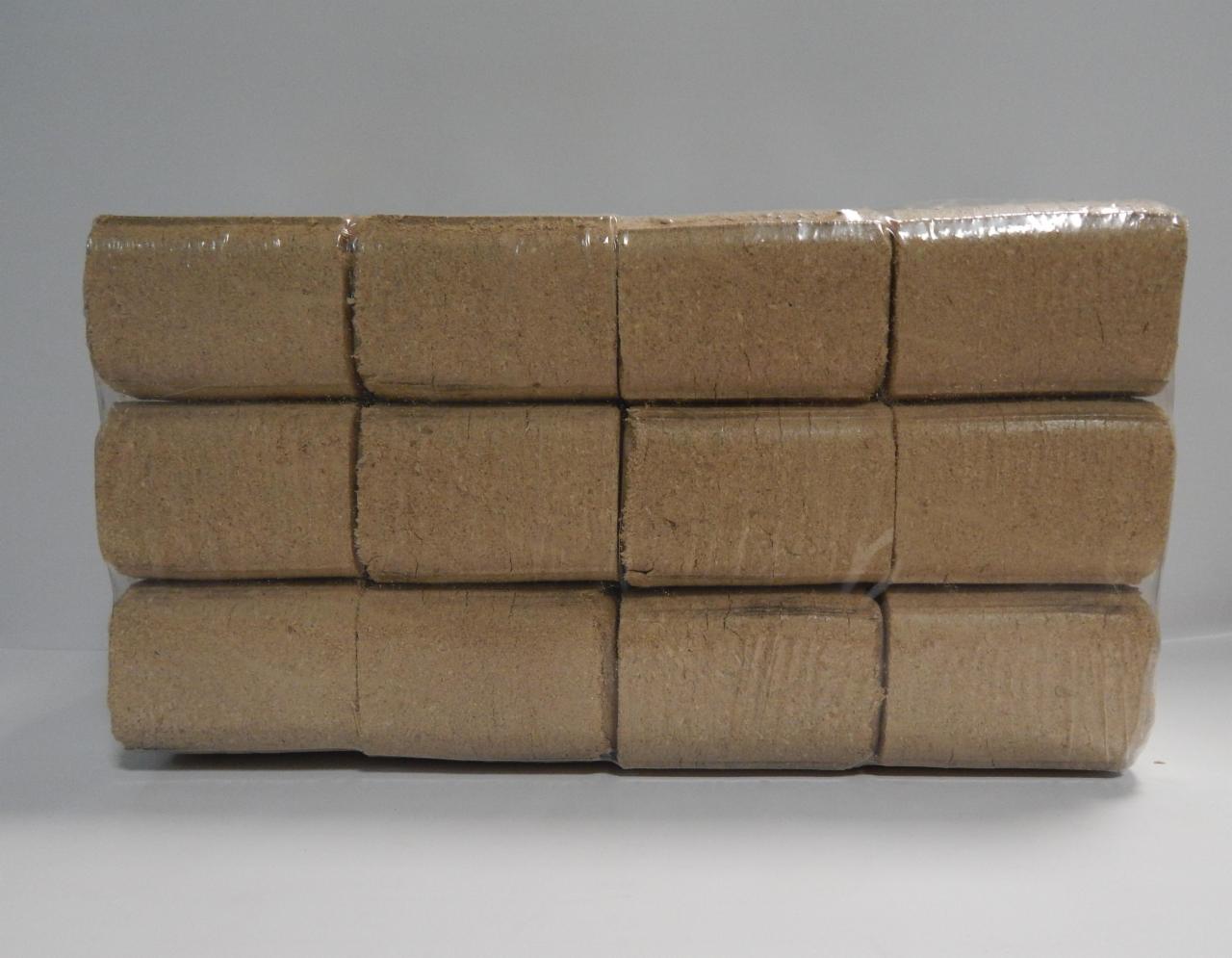 Pakiet dziewięciu kostek sprasowanych trocin w przezroczystej folii, ułożonych w trzech rzędach.