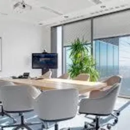 Jasne, nowocześnie urządzone biuro w Łodzi z dużym oknem, widokiem na miasto, stołem konferencyjnym i tablicą suchościeralną.