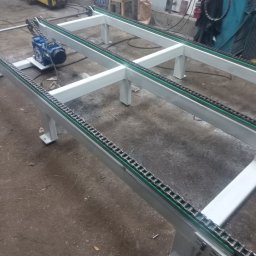 USŁUGI TOKARSKO-ŚLUSARSKIE ARIEL SKUCZYŃSKI - Metalowa konstrukcja przenośnika łańcuchowego z silnikiem elektrycznym, widoczne spawane elementy ramy i łańcuch transportowy