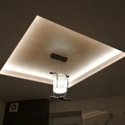 Kwadratowy sufit podwieszany z oświetleniem LED i dekoracyjną fakturą, z wiszącą lampą z abażurem w stylu retro, widok z dołu w łazience.