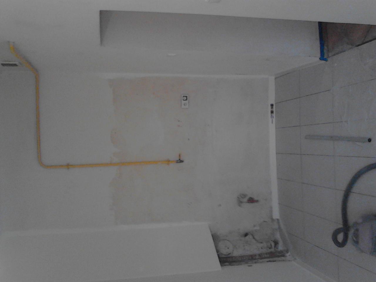 Remont łazienki: ściany przygotowane do malowania, widoczna instalacja gazowa i fragment ułożonych płytek. Prace wykończeniowe w trakcie.