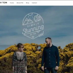 Strona internetowa z logo 'Simply Stunning by Tom' prezentująca parę na tle kwitnących krzewów i błękitnego nieba.
