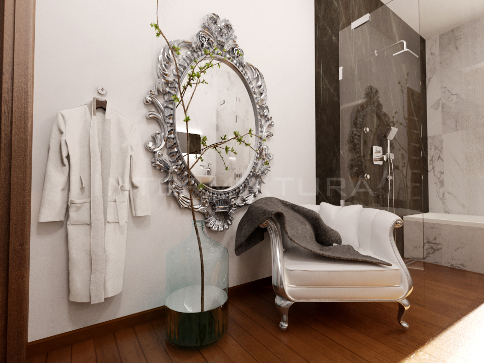 Luksusowa łazienka z ozdobnym lustrem w srebrnej ramie, białą szatą zawieszoną na ścianie, szklanym wazonem z gałązkami i białą sofą z narzuconym szarym pledem, widok na przeszklony prysznic.