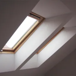 Poddasze z dwoma oknami dachowymi w drewnianych ramach, białe ściany, widok z dołu.