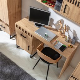 Moryc Studio - Aranżacja biurka z drewna w pokoju, z laptopem, monitorem i krzesłem. Ustawione zabawki i figurki. Całość w ciepłej tonacji, z widoczną strukturą drewna.