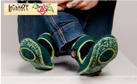 Osoba w dżinsach siedzi na białym tle, prezentując zielono-czarne, ręcznie robione kapcie z ozdobnym guzikiem z boku.