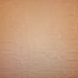 Beżowa ściana z fakturą imitującą nieregularne, płaskie kamienie ułożone w siatkę. Delikatne cieniowanie podkreśla trójwymiarowość wzoru.