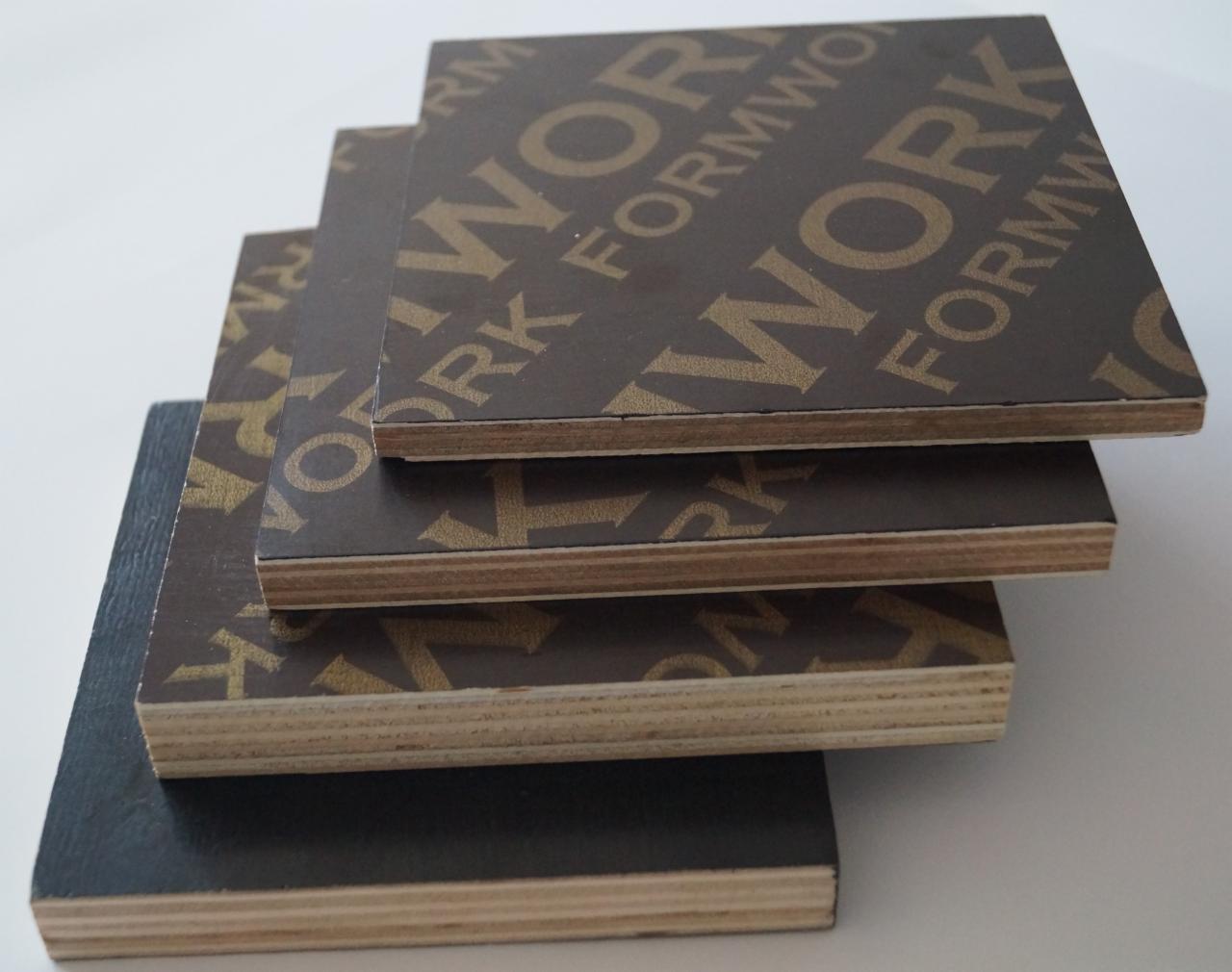Stos czterech płyt szalunkowych z widocznym przekrojem warstw drewna i ciemnobrązowym laminatem z nadrukiem 'WORK FORMWOOD'.