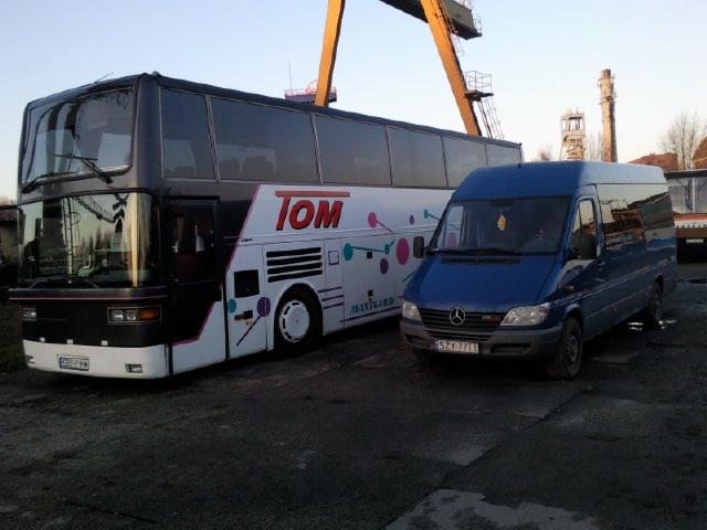 Czarno-biały autobus piętrowy TOM i niebieski bus Mercedes na tle żurawia portowego. Usługi transportowe.