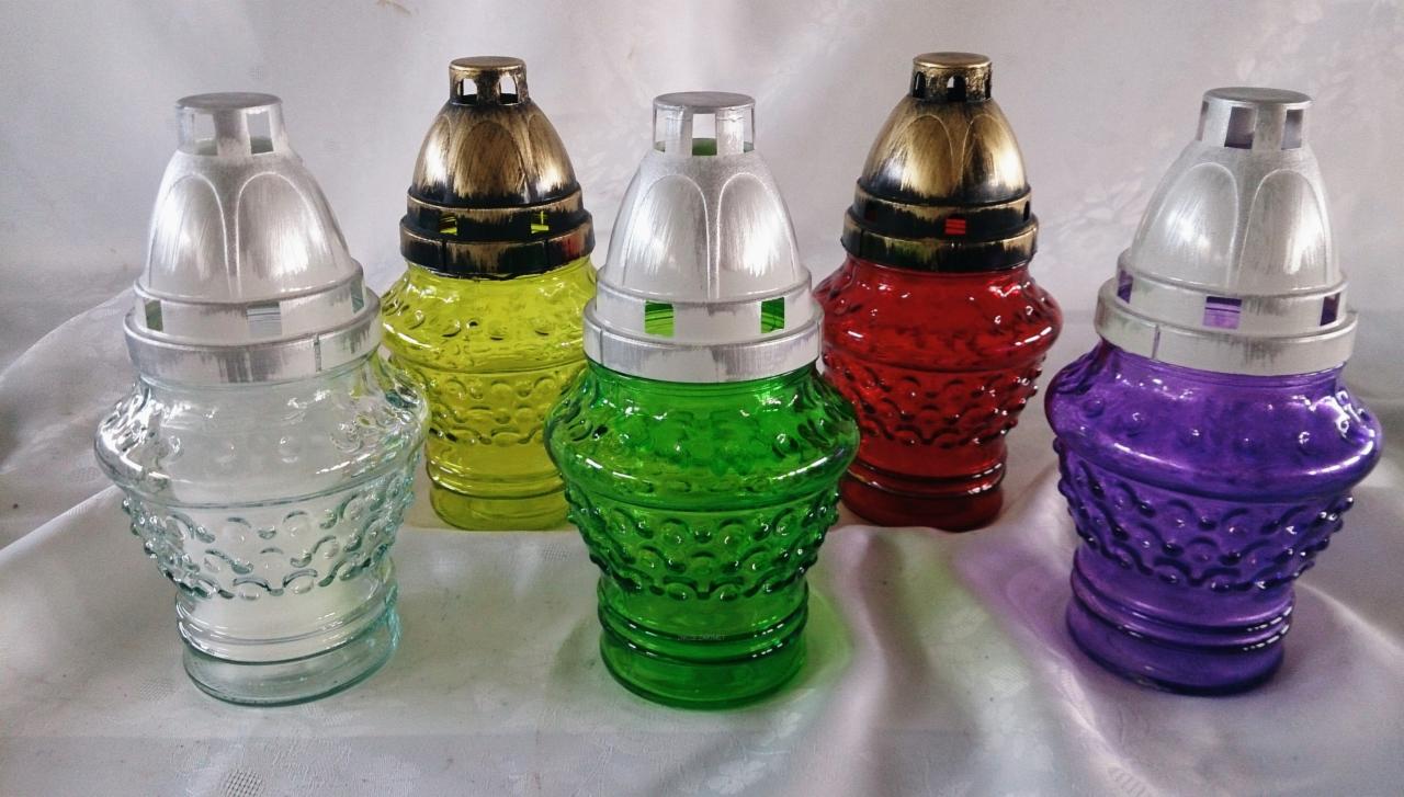 Kolorowe lampiony szklane z metalowymi nakryciami, ustawione na białym obrusie, w odcieniach: przezroczystym, żółtym, zielonym, czerwonym i fioletowym.