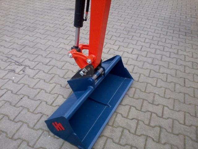 Niebieska łyżka koparki z czerwonym logo na tle szarej kostki brukowej. Hydrauliczny siłownik i pomarańczowe ramię. Widok z bliska na osprzęt roboczy.