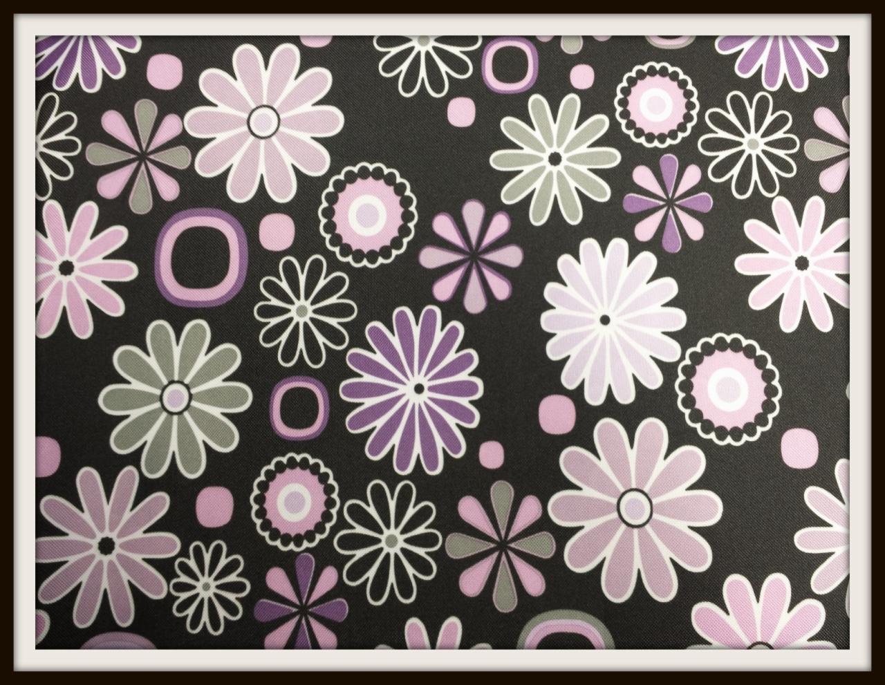 Czarny materiał w kwiaty i koła w odcieniach fioletu, różu i szarości. Wzór równomiernie rozmieszczony, kwiaty o różnych kształtach i rozmiarach.