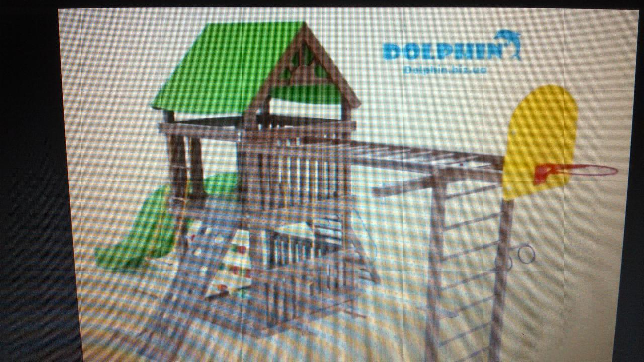 Drewniany plac zabaw z zieloną zjeżdżalnią i drabinkami, zakończony żółtym koszem do koszykówki. Widoczne logo producenta.