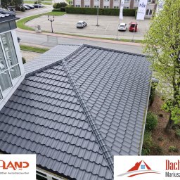 DACH-MAR Mariusz Adamczewski - Szary dach z dachówki ceramicznej widziany z góry, z fragmentem przeszklonej konstrukcji i zielenią w tle. Widoczne logotypy firm na dole kadru.