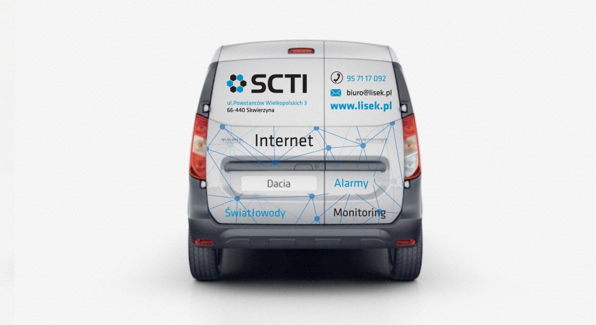 Projekt reklamy na tylnej części samochodu dostawczego marki Dacia, z logo SCTI, danymi kontaktowymi oraz hasłami: Internet, Alarmy, Światłowody, Monitoring, połączonymi graficznie siecią.