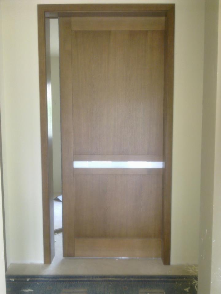 Zamknięte, drewniane drzwi wewnętrzne z poziomym, mlecznym przeszkleniem w ramie. Widok z bliska, neutralne oświetlenie, wnętrze domu.