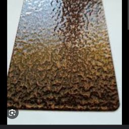 Kowalstwo Kubala - Metalowa powierzchnia z fakturą antycznej miedzi, zbliżenie na nieregularną, chropowatą teksturę w odcieniach brązu i miedzi.