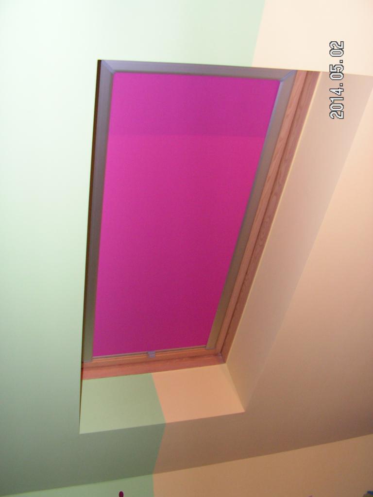 Okno dachowe z zasłoną w odcieniu fuksji, widok od dołu. Fragment ściany w pastelowych kolorach. Data 2014.05.02 w prawym górnym rogu.