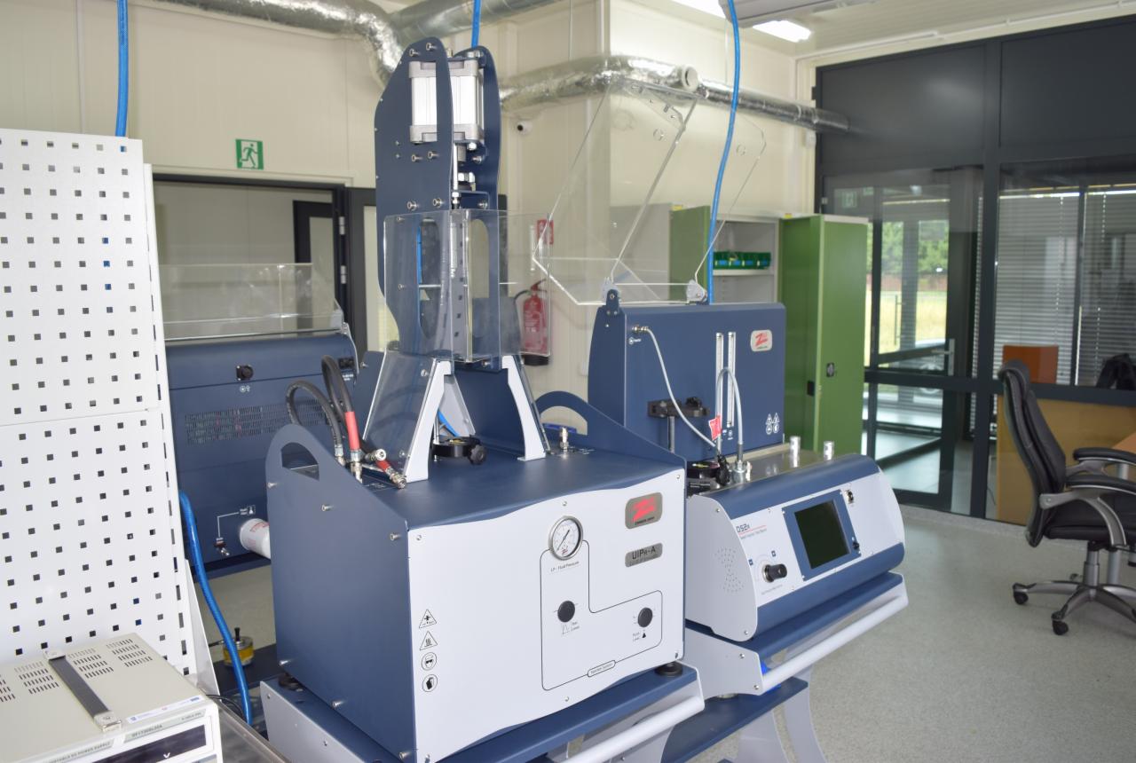 Laboratory setting with specialized testing equipment, including devices labeled UIP4-A and DS2x, showcasing precision instruments in a bright, clean environment.