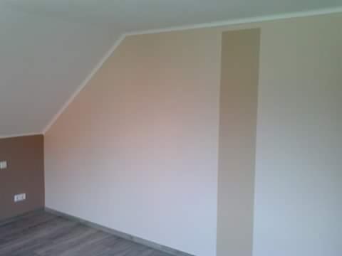 Pokój na poddaszu po malowaniu ścian w odcieniach beżu i brązu, z widoczną poziomą listwą przy suficie i fragmentem szarej podłogi.