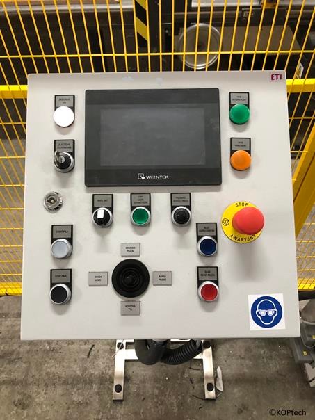 Panel sterowania maszyny przemysłowej z przyciskami, ekranem dotykowym Weintek, wyłącznikiem awaryjnym i naklejką BHP z okularami ochronnymi.