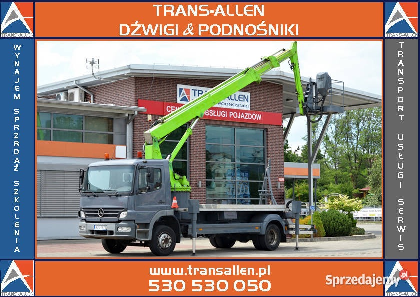 Podnośnik koszowy na samochodzie marki Mercedes-Benz, zaparkowany przed budynkiem z logo firmy Trans-Allen, oferującej usługi dźwigowe i podnośnikowe.