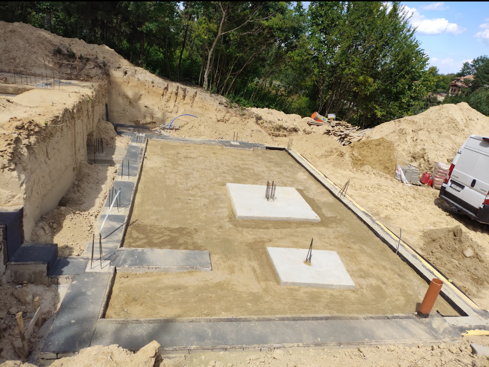 Przygotowany fundament z izolacją w Zemborzycach Tereszyńskich. Widoczne zbrojenia i podłoże pod wylewkę. Wykop ziemny pod budowę domu.