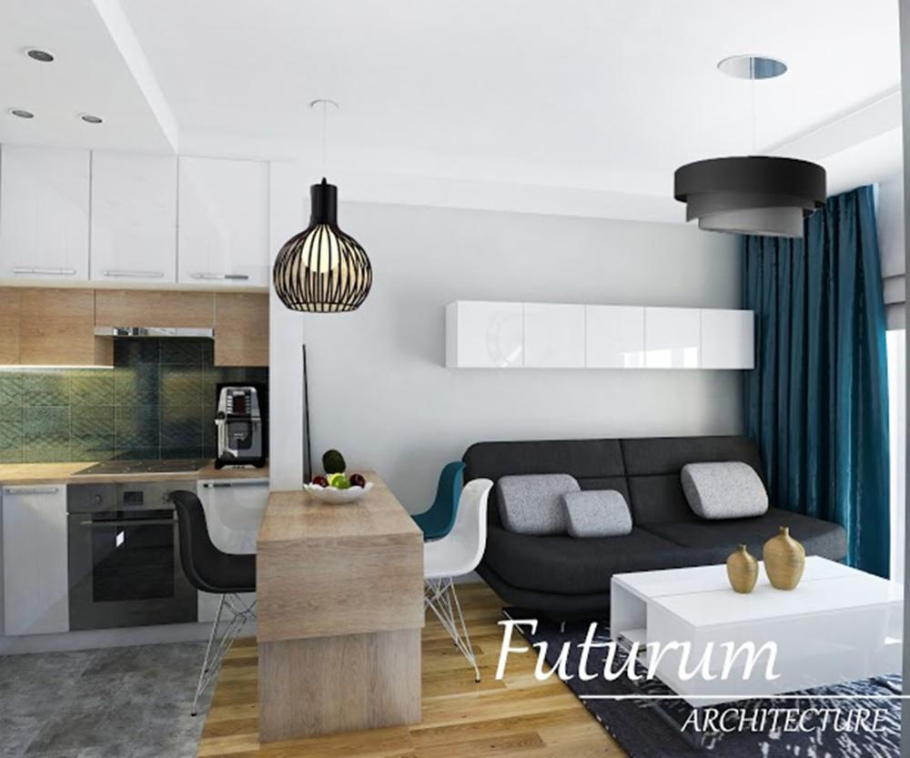 Nowoczesne wnętrze: aneks kuchenny z drewnianym blatem i czarnymi krzesłami, obok sofa z poduszkami i stolikiem. Wiszące lampy dodają charakteru aranżacji.