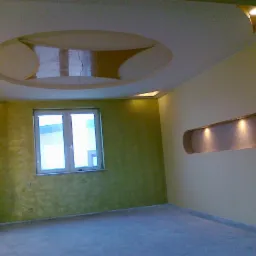 Nowoczesne wnętrze z zieloną ścianą, oknem i podwieszanym sufitem z oświetleniem punktowym. Dekoracyjna wnęka ścienna z oświetleniem.