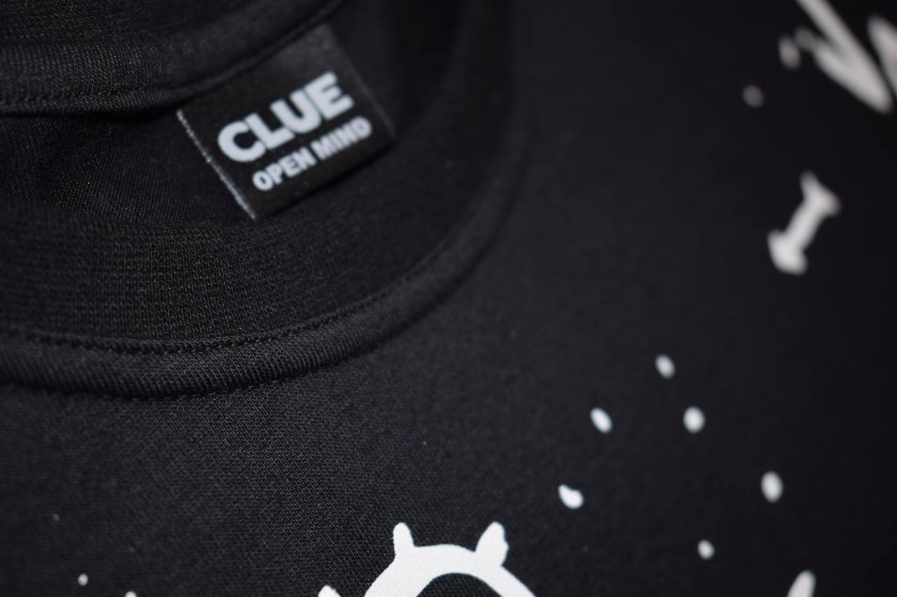 Czarna koszulka z białym nadrukiem i metką 'CLUE OPEN MIND', wykonana w szwalni w Łańcucie.