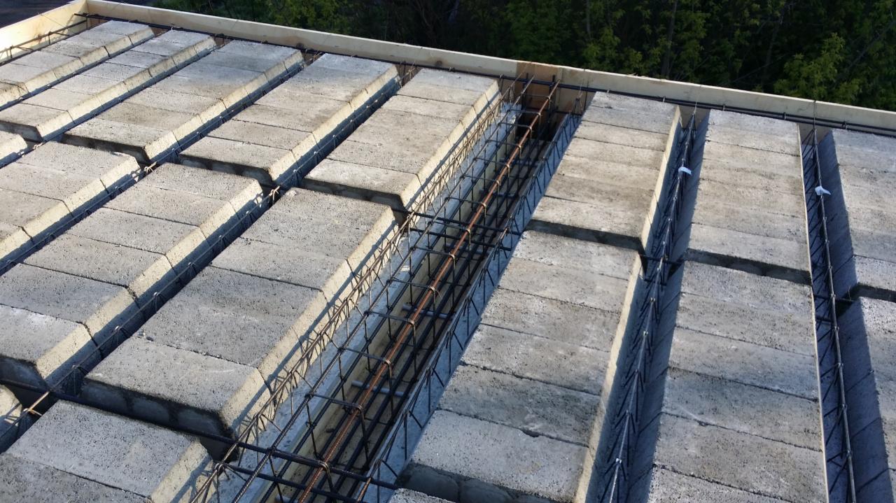 Konstrukcja stropu Teriva z pustaków betonowych i zbrojeniem stalowym w trakcie budowy domu, widok z góry.