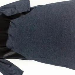 Szaro-czarna sukienka z długim rękawem, leżąca na białym tle. Widoczny detal wykończenia z tyłu. Odzież damska w neutralnej tonacji.