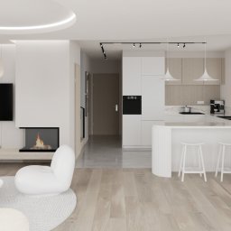 Czwarty Wymiar - Nowoczesne, jasne wnętrze z otwartą kuchnią, białymi meblami i drewnianą podłogą. Widoczny salon z kominkiem i minimalistycznymi lampami.