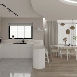 Czwarty Wymiar - Elegancka, minimalistyczna kuchnia z jadalnią w jasnych barwach. Białe meble kuchenne, marmurowy blat, okrągły stół z krzesłami i duże okna z widokiem na zieleń.