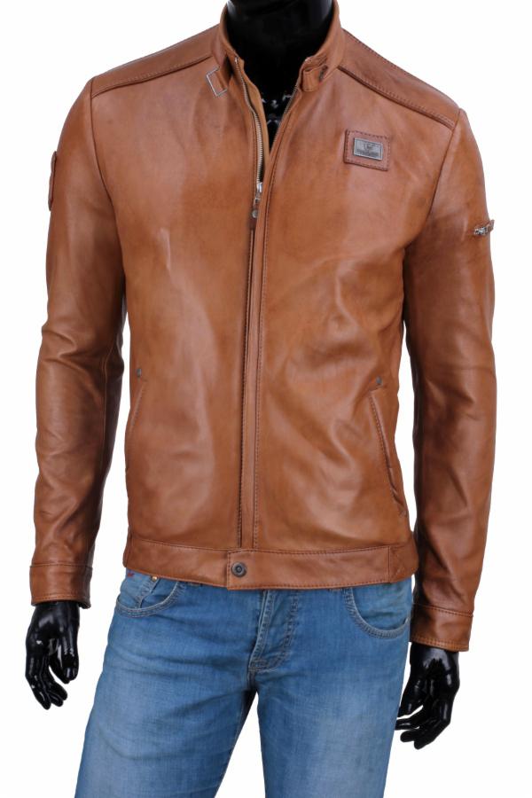 Brązowa kurtka skórzana z metalowym logo na manekinie w Elblągu. Widoczne kieszenie, zamek i dżinsy. Detal odzieży męskiej z bliska.