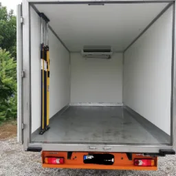 Wnętrze chłodni samochodowej z zamontowanym agregatem chłodniczym marki Zanotti, widoczne zabezpieczenia ładunku z żółtymi elementami.