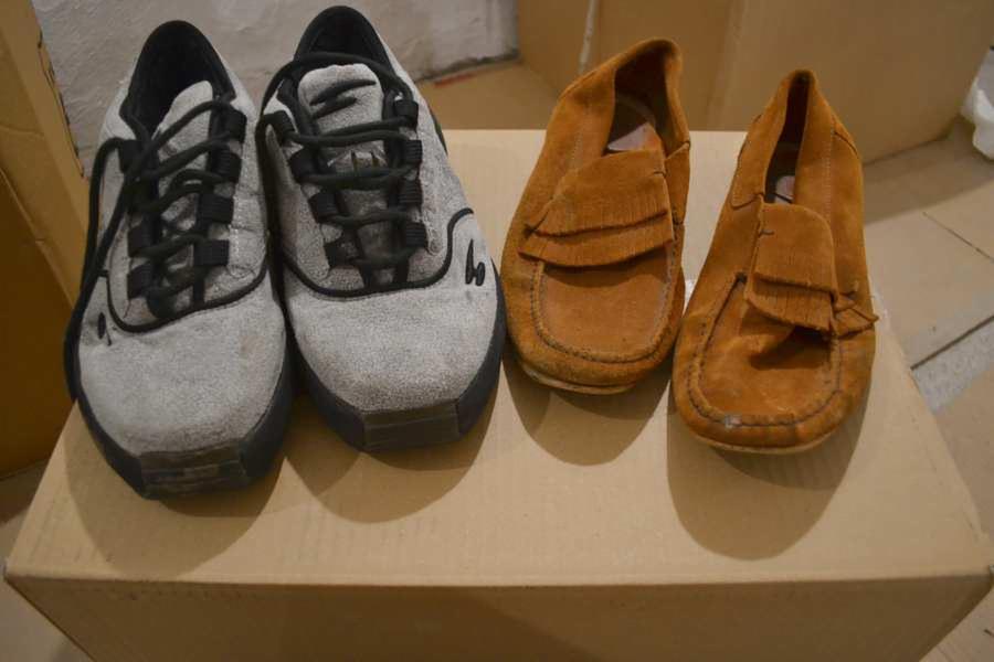 Para szarych butów sportowych i para brązowych mokasynów z frędzlami, wystawione na sprzedaż w Brzesku. Obuwie używane.
