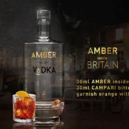 Butelka wódki Amber Inside Vodka i drink na tle londyńskiej budki telefonicznej i pubu The Hive Inn. Kompozycja z elementami brytyjskiego klimatu.
