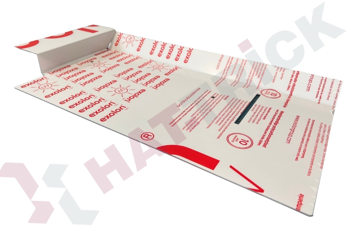 Arkusz poliwęglanu Exolon z nadrukowanym logo i informacjami o produkcie, prezentowany pod kątem, ukazujący detale nadruku i właściwości materiału.