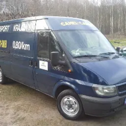 Niebieski bus Ford Transit z napisem 'Transport Krajowy' i numerem telefonu, zaparkowany na zewnątrz. Widoczny cennik 0,80 zł/km.